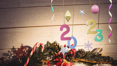 Animation-of-2023-text-and-christmas-decorations-in-background