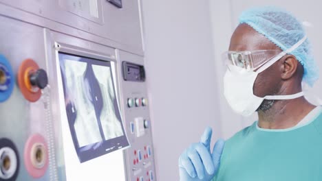 Video-Eines-Afroamerikanischen-Männlichen-Chirurgen,-Der-Vor-Der-Operation-Im-Operationssaal-Röntgenuntersuchungen-Durchführt