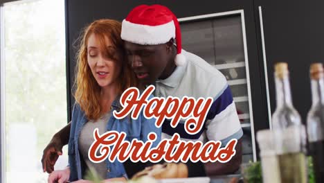 Animation-of-christmas-greetings-text-over-diverse-couple-in-kitchen-at-christmas