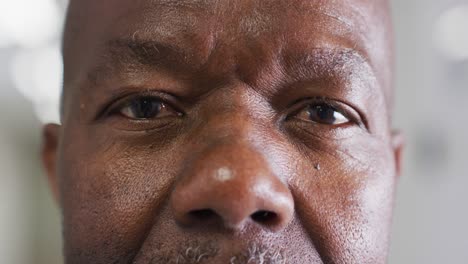 Video-close-up-portrait-of-the-opening,-blinking-eyes-senior-african-american-male-doctor