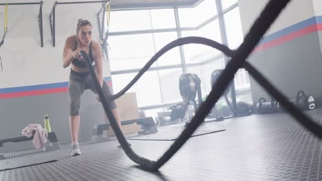 Video-of-determined-caucasian-woman-working-out-at-a-gym-with-battling-ropes