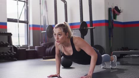 Video-of-determined-caucasian-woman-doing-push-ups-working-out-at-a-gym