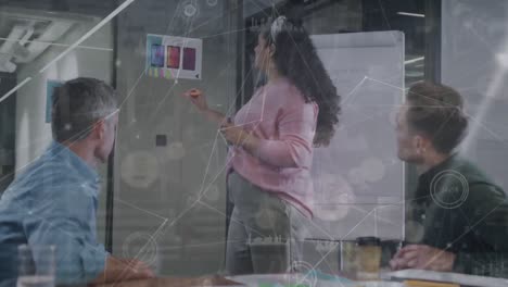 Animation-of-connected-dots-and-graph-icons-over-diverse-coworkers-discussing-ideas-over-glass-board