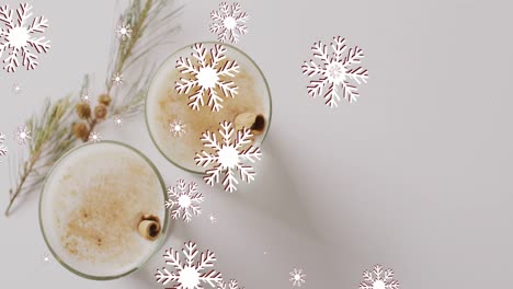 Animation-of-snow-falling-over-christmas-drinks-and-decoration