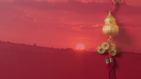 Animation-of-sunset-over-chinese-traditional-decorations-on-red-background