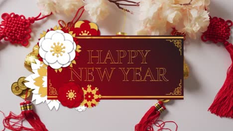 Animation-of-new-year-greetings-text-over-chinese-traditional-decorations-on-white-background