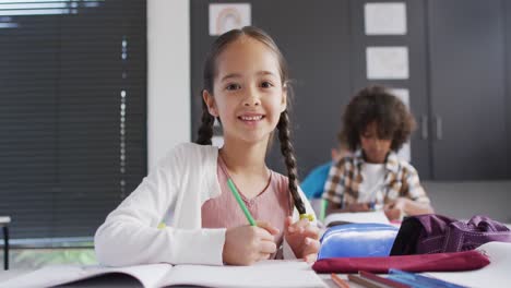 Porträt-Glücklicher,-Vielfältiger-Schulkinder-An-Schreibtischen-Im-Klassenzimmer