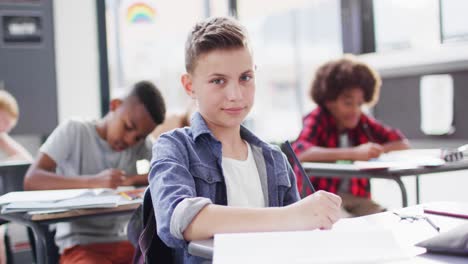 Porträt-Glücklicher,-Vielfältiger-Schulkinder-An-Schreibtischen-Im-Klassenzimmer