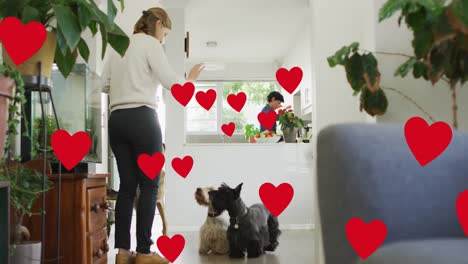 Animation-Von-Herzen-über-Einem-Kaukasischen-Weiblichen-Paar-Mit-Ihrem-Hund