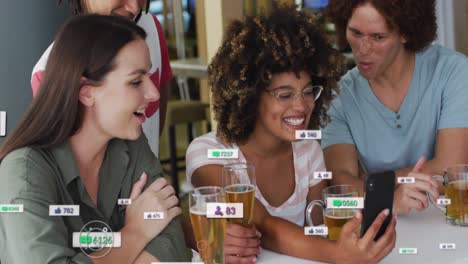 Animation-of-media-icons-over-happy-diverse-friends-drinking-beer