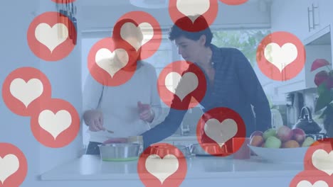 Animation-of-heart-emojis-over-happy-caucasian-female-couple