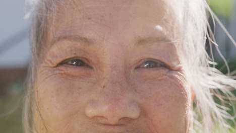 Portrait-of-happy-asian-senior-woman-on-sunny-day-in-garden