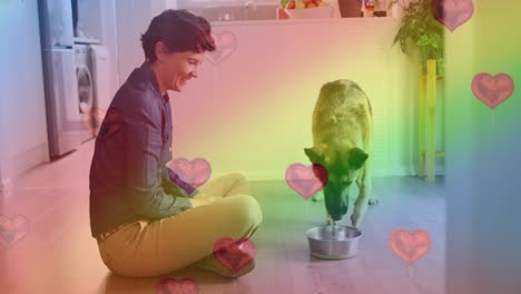 Animation-of-heart-emojis-and-rainbow-flag-over-caucasian-woman-with-dog