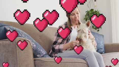 Animation-of-heart-emojis-over-happy-caucasian-woman-with-dog