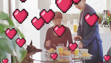 Animation-Von-Herz-Emojis-über-Einem-Glücklichen-Kaukasischen-Frauenpaar-Mit-Hund