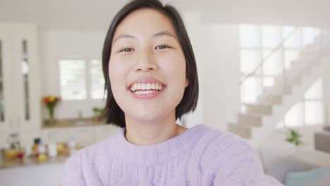 Porträt-Einer-Glücklichen-Asiatischen-Frau,-Die-Im-Wohnzimmer-Einen-Videoanruf-Führt