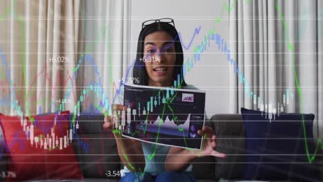 Animation-of-financial-data-processing-over-biracial-businesswoman-holding-sheet-with-statistics