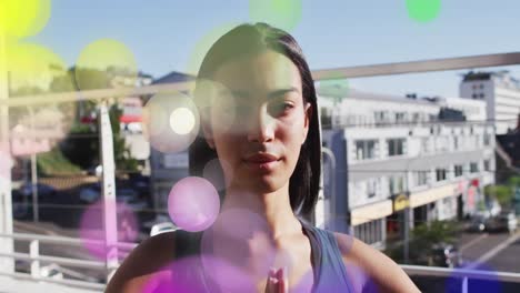 Animation-of-glowing-lights-over-biracial-woman-practicing-yoga