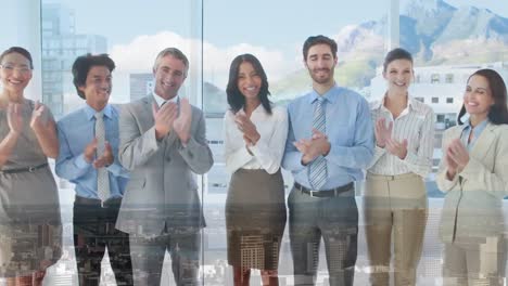 Animation-of-aerial-view-of-cityscape-over-diverse-coworkers-standing-in-row-and-clapping-in-office