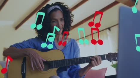 Animation-of-music-notes-over-biracial-woman-playing-guitar-and-using-lapotp