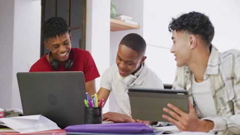 Tres-Amigos-Adolescentes-Varones-Felices-Y-Diversos-Usando-Laptop-Y-Tableta-En-Casa,-Cámara-Lenta