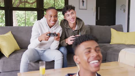 Happy-diverse-male-teenage-friends-playing-video-games-at-home,-slow-motion