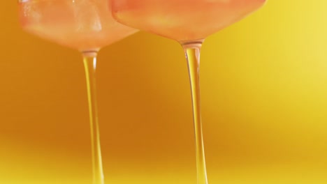 Close-up-of-drink-with-cherry-on-yellow-background