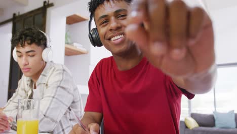 Portrait-of-happy-diverse-male-teenage-friends-having-video-call-at-home,-slow-motion