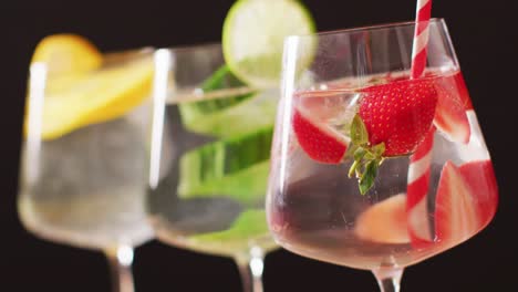 Close-up-of-drinks-with-fruit-on-black-background