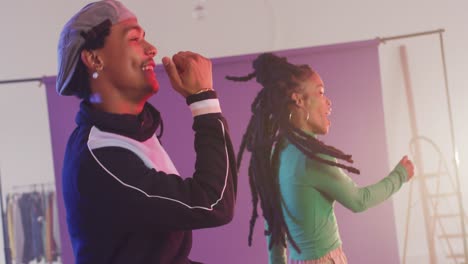 Happy-biracial-male-and-female-dancers-dancing-together-in-dance-studio,-slow-motion