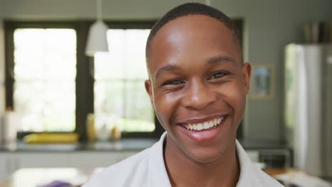 Portrait-of-happy-african-american-male-teenage-boy-at-home,-slow-motion