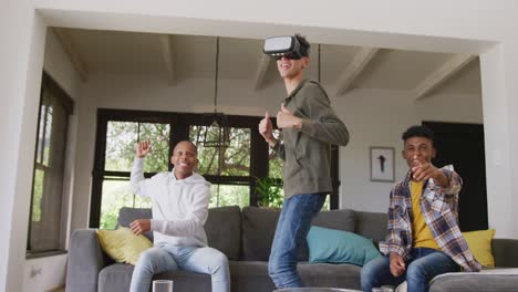 Happy-diverse-male-teenage-friends-playing-video-games-and-using-vr-headset-at-home,-slow-motion