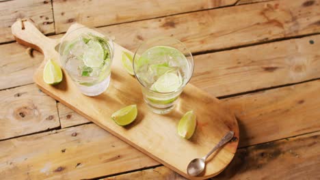Close-up-of-drinks-with-lemons-on-wooden-board,-with-copy-space