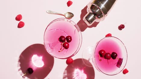 Close-up-of-drinks-with-cherries-and-shaker-on-white-background