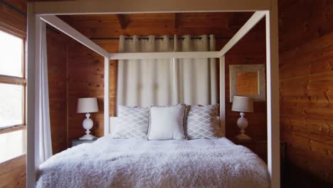General-view-of-bedroom-with-master-bed-in-log-cabin,-slow-motion