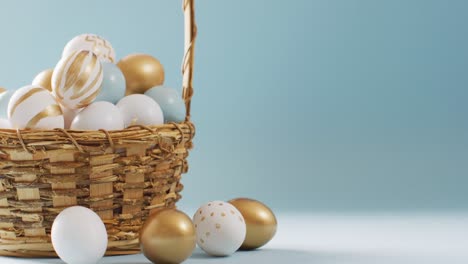Basket-with-colorful-easter-eggs-on-blue-background-with-copy-space