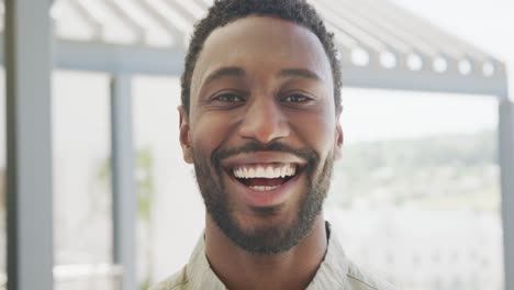 Porträt-Eines-Glücklichen-Afroamerikanischen-Geschäftsmannes,-Der-In-Die-Kamera-Blickt-Und-Im-Büro-Lächelt,-Zeitlupe