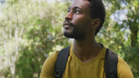Happy-african-american-man-with-backpack-in-park,-slow-motion