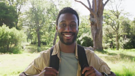 Portrait-of-happy-african-american-man-looking-at-camera-in-park,-slow-motion