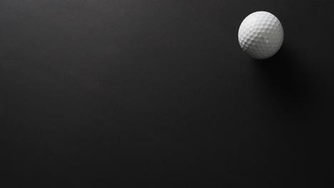 Nahaufnahme-Eines-Golfballs-Auf-Schwarzem-Hintergrund,-Kopierraum,-Zeitlupe