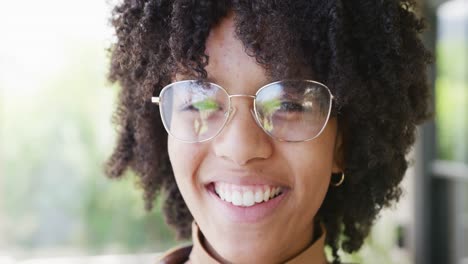 Portrait-of-happy-african-american-teenage-girl-wearing-glasses,-smiling-and-laughing,-slow-motion