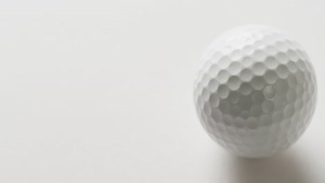 Close-up-of-golf-ball-on-white-background,-copy-space,-slow-motion