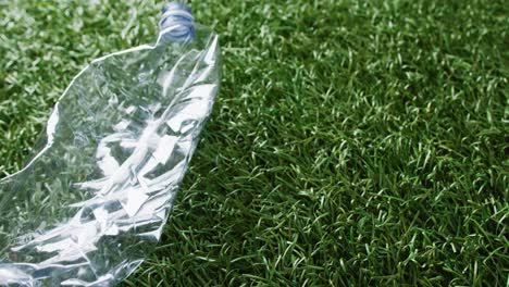 Close-up-of-plastic-bottle-trash-on-grass-background,-with-copy-space