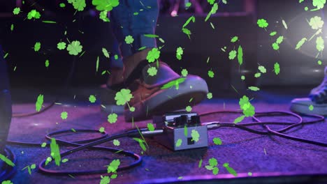 Animation-of-st-patrick's-day-green-shamrock-falling-over-man-playing-on-concert-stage
