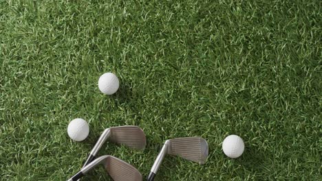 Close-up-of-golf-clubs-and-balls-on-grass,-copy-space,-slow-motion