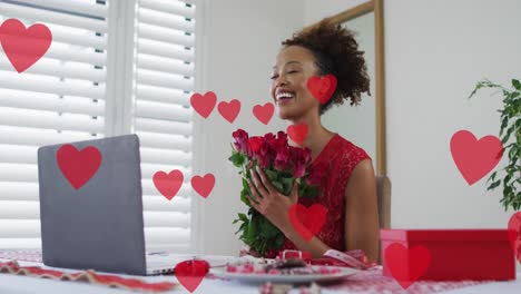 Animation-of-heart-icons-over-african-american-woman-using-laptop-for-video-call