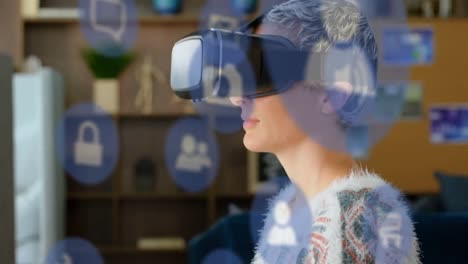 Animation-of-multiple-digital-icons-floating-over-caucasian-woman-wearing-vr-headset-at-office