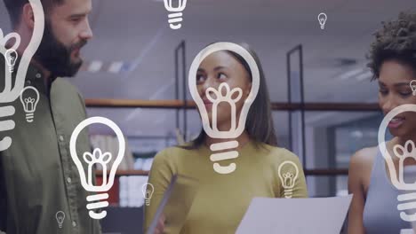 Animation-of-light-bulb-icons-and-data-processing-over-diverse-business-people