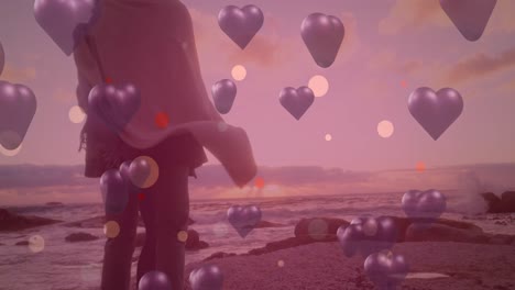 Animation-of-purple-hearts-over-couple-in-love-by-seaside