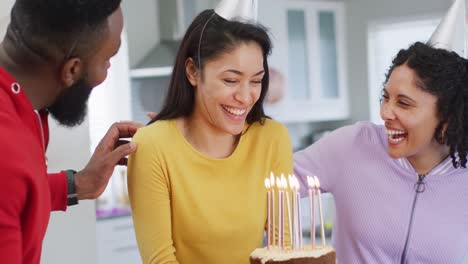 Happy-biracial-woman-holding-birthday-cake-celebrating-birthday-with-diverse-friends,-in-slow-motion